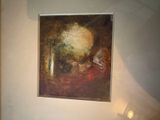 une photo d'un tableau accroché au mur au-dessus d'un lit
