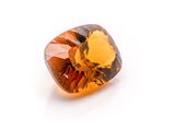 a close up of a square cut orange sapphire stone on a white surface