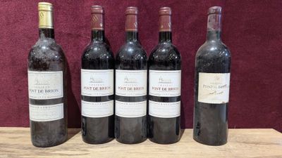 six bottles of wine are lined up on a wooden table