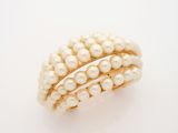 an image of a pearl and gold ring on a white surface