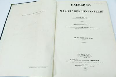 un livre ouvert posé sur une table à côté d'une table blanche