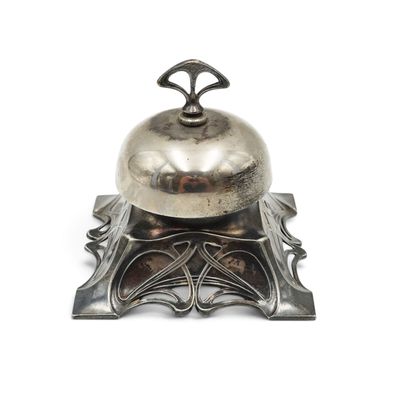 a silver bell sitting on top of a metal stand