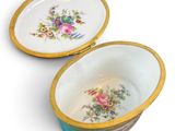 pair of porcelain bowls with floral designs on them on a white surface