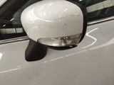 a side view mirror on a white car in a showroom
