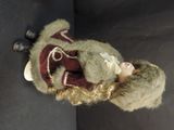 a doll that is wearing a hat and a sweater