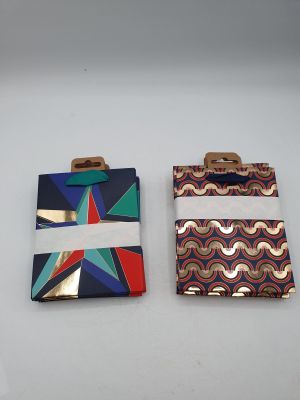 two pieces of fabric with geometric designs on them sitting on a white surface
