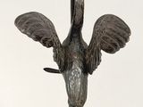 bronze sculpture of a bird on a marble base on a white background