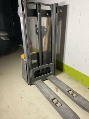 a fork lift truck parked in a garage next to a wall