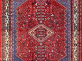 a red and blue rug with an ornate design