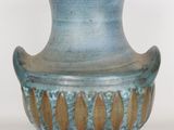 a blue vase that is sitting on a white surface