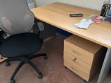 a desk with a chair and a file cabinet in the corner