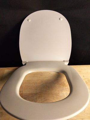 a white toilet with a wooden seat on a wooden floor