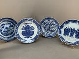 quatre assiettes bleues et blanches ornées de motifs