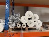 many rolls of paper on a shelf in a warehouse
