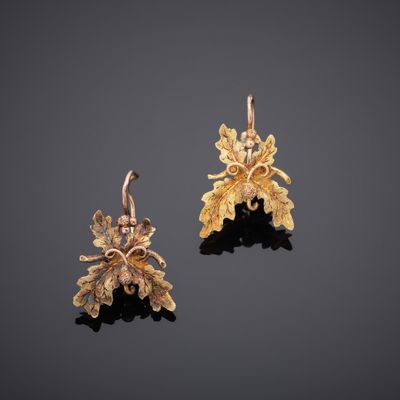 a pair of gold earrings with leaves and flowers
