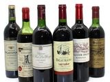 several bottles of wine are lined up on a white surface