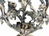 a bird nest in the middle of a metal candle holder