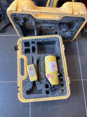 une mallette jaune contenant des outils, posée par terre à côté d'une boîte à outils