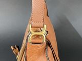 a close up of a brown purse on a black surface