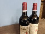 two bottles of wine sitting on a wooden table