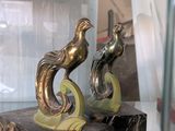 deux statues représentant un oiseau, posées sur un socle en marbre