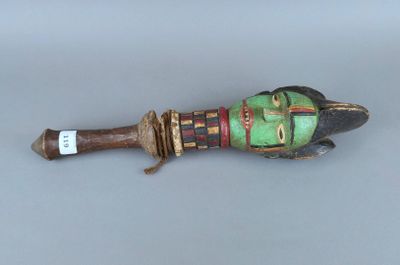 un petit objet en bois sur lequel est représenté un visage vert