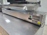 stainless steel counter top in a commercial kitchen with a television on top