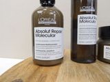 two bottles of hair products sitting on a cutting board
