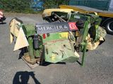 un tracteur posé au sol, sur lequel est accrochée une pancarte