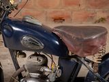 a blue motorcycle parked in front of a brick wall