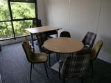 une table et des chaises dans une pièce avec une grande fenêtre
