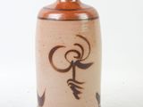 a brown vase with a design on it on a white surface