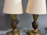 une paire de lampes de table en laiton, chacune dotée d'un abat-jour blanc