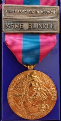 un ruban violet et bleu surmonté d'une médaille d'or