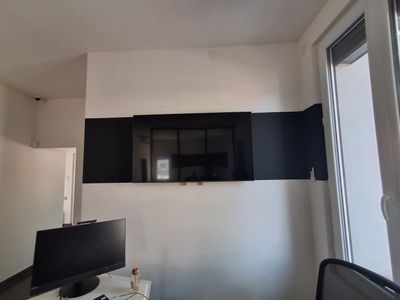 a desk with a computer and a monitor in a room