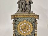 une statue de femme assise au sommet d'une horloge
