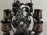 a picture of a black and white vase and cups on a table