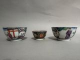 three small bowls are sitting on a white surface, one has a painting of a man and the other has a woman