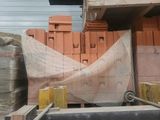 un tas de briques posé sur une palette à côté d'un bâtiment