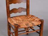 une vieille chaise en bois avec une assise tressée sur fond gris