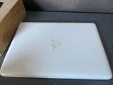 a white apple laptop sitting on a table next to a wooden box