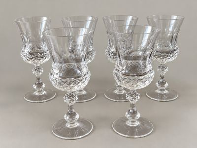 four clear wine glasses sitting on top of a table next to each other