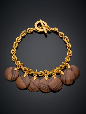 un bracelet en or orné de disques en bois et d'une chaîne en or