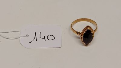 une bague en or sertie d'une pierre noire, avec une étiquette de prix
