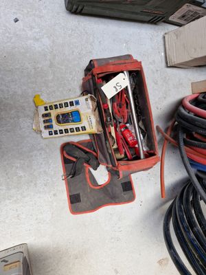 une boîte contenant du matériel électrique posée par terre à côté d'une boîte de câbles