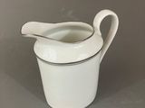 a close up of a white and black gravy dish with a spoon in it