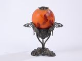un vase en verre orange orné d'un motif de feuilles