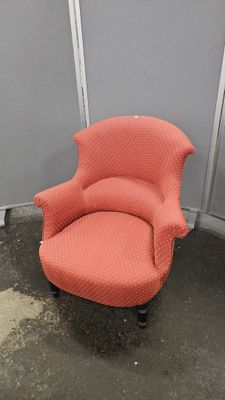 une chaise rouge qui se trouve dans le coin d'une pièce