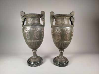 deux vases en argent posés l'un à côté de l'autre sur une table