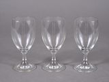 three empty wine glasses sitting on top of a table